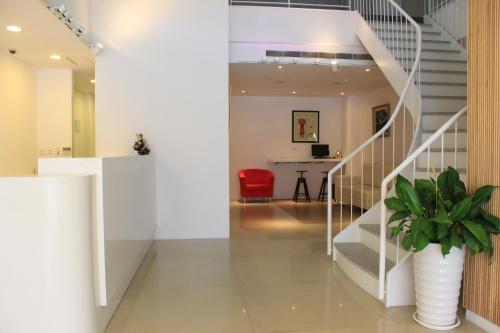 a hallway with a staircase and a red chair at Sunnyside Hotel in Kaohsiung