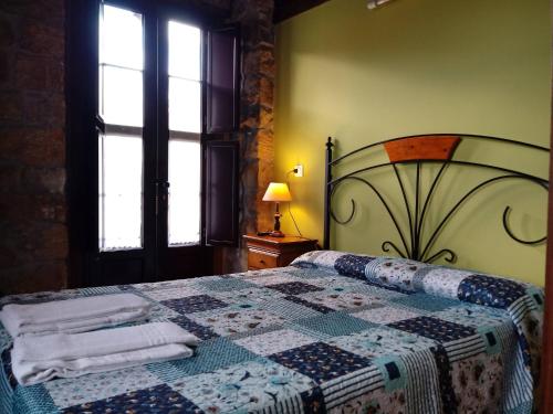 a bedroom with a bed with a quilt on it at Hotel Rural Posada Del Monasterio in Cangas de Onís