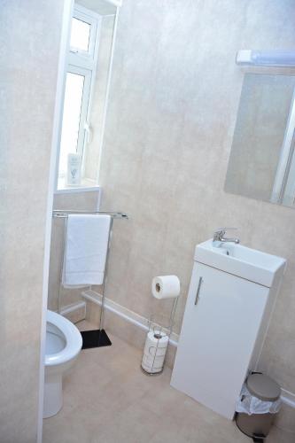 a white bathroom with a toilet and a window at The Oxfordshire in Blackpool