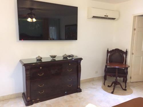 a room with a dresser and a chair and a mirror at Hotel Boutique Villa Casuarinas in Cali
