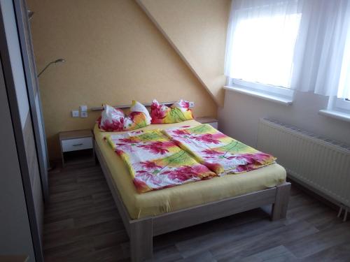 a small bedroom with a bed with a colorful blanket at Pension zum Ringelberg in Erfurt