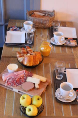 a table with plates of food and cups of coffee at Les Glycines in Remoulins