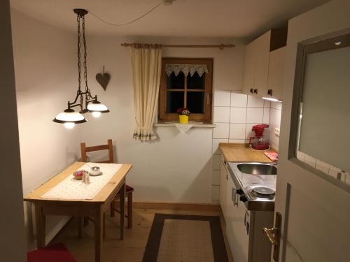 eine kleine Küche mit einem Tisch und einem Waschbecken in der Unterkunft Ferienwohnung Sachrang in Sachrang