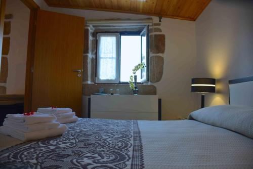 um quarto com uma cama com toalhas em Cidadelhe Rupestre Turismo Rural em Cidadelhe