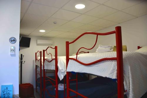 a bedroom with two beds with red metal frames at Cidadelhe Rupestre Turismo Rural in Cidadelhe