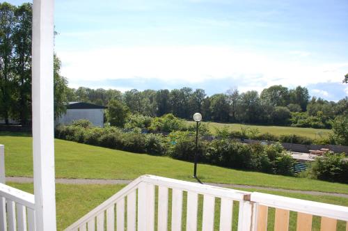 a porch with a white fence and a view of a yard at Allégården Kastlösa Stugor in Mörbylånga