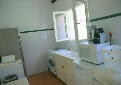 uma cozinha com um lavatório e uma máquina de lavar roupa em Maja em Favone