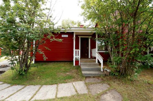 a red house with a staircase leading to the door at Ylläksen Yöpuu in Äkäslompolo