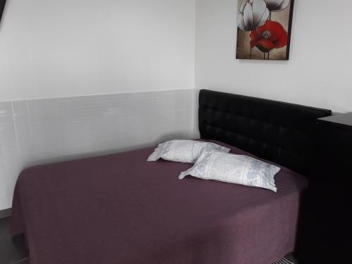 een slaapkamer met een bed met 2 kussens erop bij Nazaré - The Little Star in Nazaré