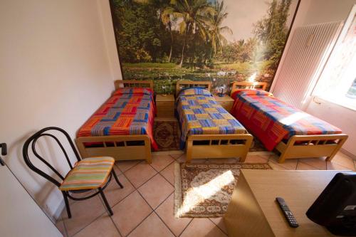 a room with three beds and a table and chairs at Bed & Breakfast Porta Santi in Cesena