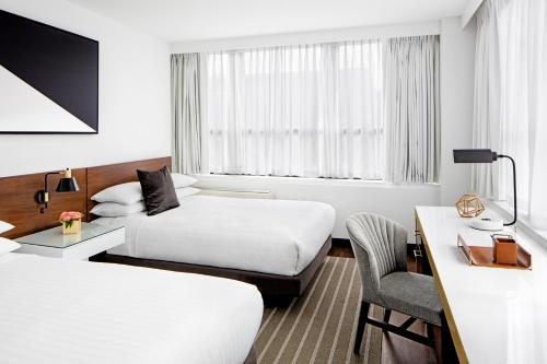 a hotel room with two beds and a desk at The St Gregory Hotel Dupont Circle Georgetown in Washington, D.C.