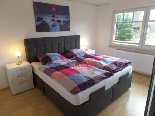 a bedroom with a large bed with a large window at Ferienhaus am Emspark in Leer