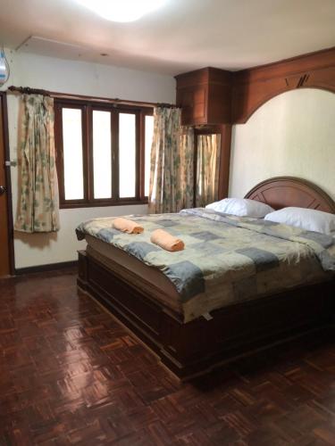 a bedroom with a large bed with two pillows on it at Dikachaya Hostel in Chaweng
