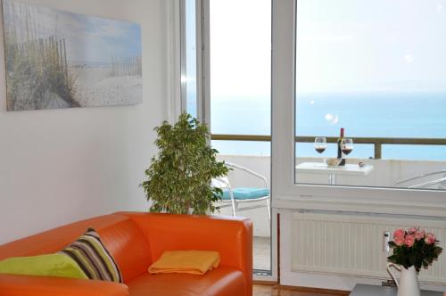 sala de estar con sofá naranja y ventana en Razgled/The View en Koper