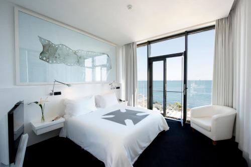 a hotel room with a bed and a chair at Farol Hotel in Cascais