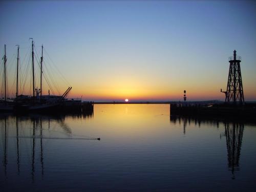 a sunset over a body of water with boats at Deo Annuente in Enkhuizen