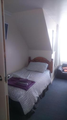 a bedroom with a bed with a purple blanket on it at Smugglers Rest in Newquay