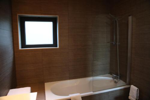 a bathroom with a bath tub and a window at Casa dos Arcos in Caramulo