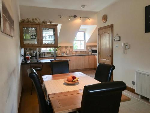 a kitchen with a table with a bowl of fruit on it at Castle View Place in Dornoch