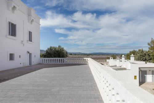 a white building with a brick walkway at Masseria San Giovanni - Epoca Collection in Fasano