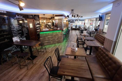 un restaurant avec des tables et des chaises en bois ainsi qu'un bar dans l'établissement Hostal Dinamarca, à Sant Antoni de Portmany