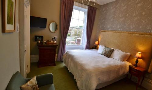 a hotel room with a bed and a window at Glendon Bed and Breakfast in Matlock