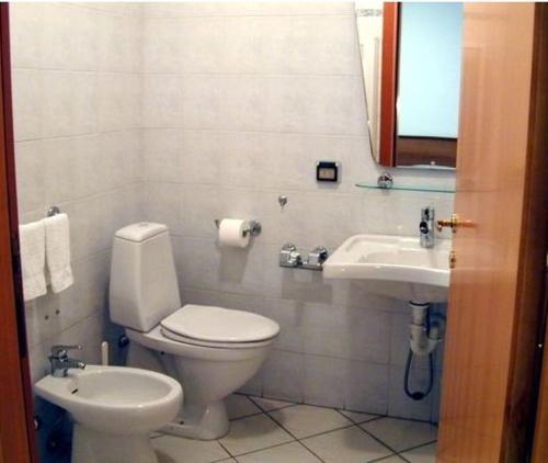 a bathroom with a toilet and a sink at Hotel Astoria in Viareggio
