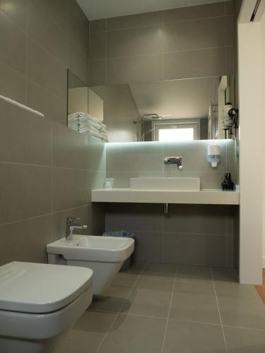 a bathroom with a toilet and a sink and a mirror at Hotel Vila da Guarda in A Guarda