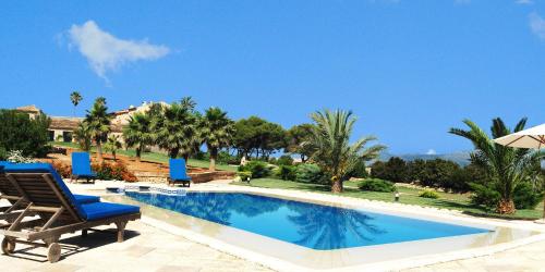 a swimming pool with a chair and an umbrella at Casal Santa Eulalia in Can Picafort