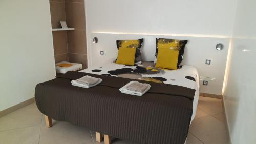 a bed in a small room with yellow pillows at Villa Perle De La Mer in Saint-Aygulf