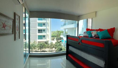 - un salon avec un lit et une grande fenêtre dans l'établissement Seaway 302, à Carthagène des Indes