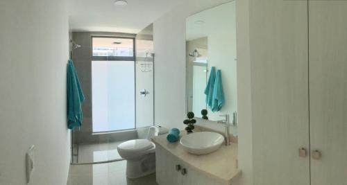 La salle de bains blanche est pourvue d'un lavabo et de toilettes. dans l'établissement Seaway 302, à Carthagène des Indes