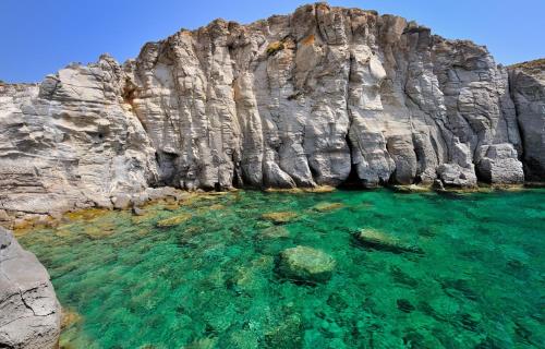 a rock cliff with a clear blue water at Casa Tartaruga in SantʼAntìoco