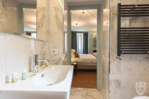 a bathroom with a tub and a sink and a bedroom at Residenza Spada in Rome