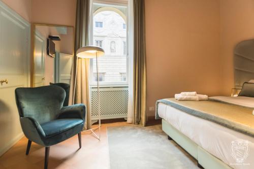 a bedroom with a bed and a chair and a window at Residenza Spada in Rome