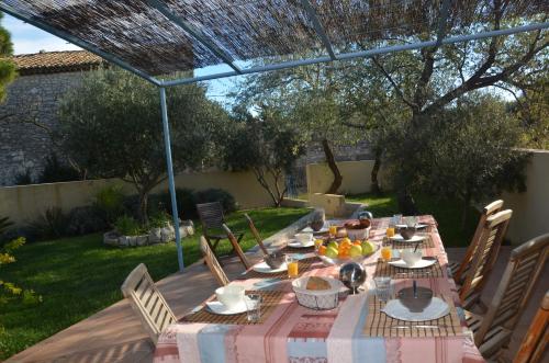 un juego de mesa para una comida en el jardín en chambres d'hôtes du moulin en Peyriac-de-Mer