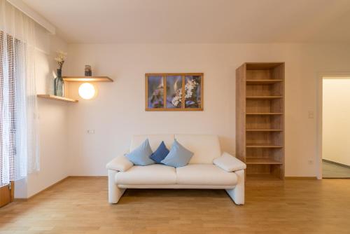 a living room with a white couch with blue pillows at Haus Piger in Termeno