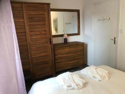 a bedroom with a bed with two white towels on it at Pilatre de Rosier proximité plage in Wimereux