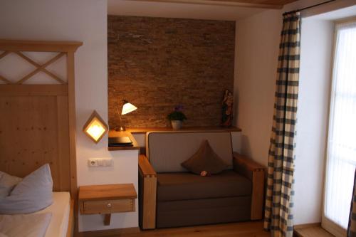 a bedroom with a couch and a brick wall at Pension Schusterpeter in Bad Tölz