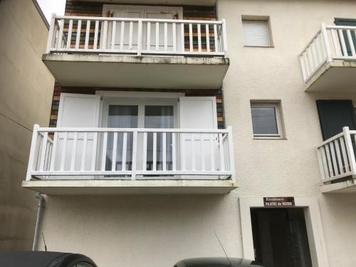 a building with white balconies on the side of it at Pilatre de Rosier proximité plage in Wimereux