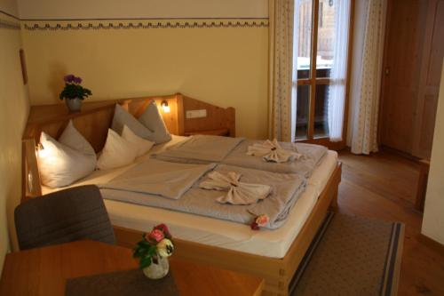 a bedroom with a large bed and a table at Pension Schusterpeter in Bad Tölz