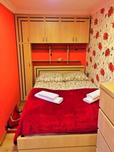 a bedroom with a red bed with two towels on it at Hotel Nestt in Stepantsminda