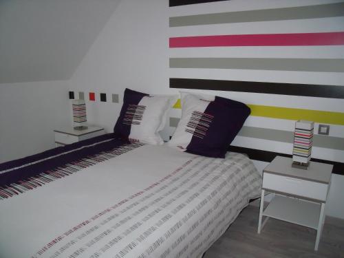 - une chambre avec un lit et un mur rayé dans l'établissement au clair de lune, à Mehun-sur-Yèvre