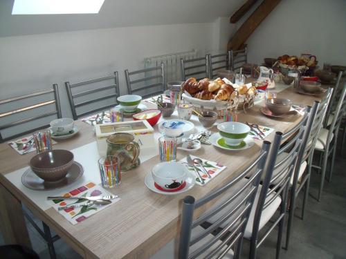 une longue table en bois avec des chaises et un bol de nourriture dans l'établissement au clair de lune, à Mehun-sur-Yèvre
