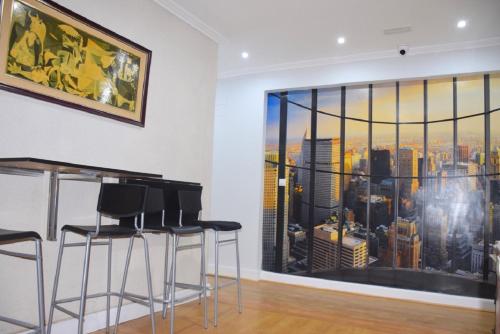 a bar with stools in a room with a large window at Maite Urban Dreams in Barakaldo