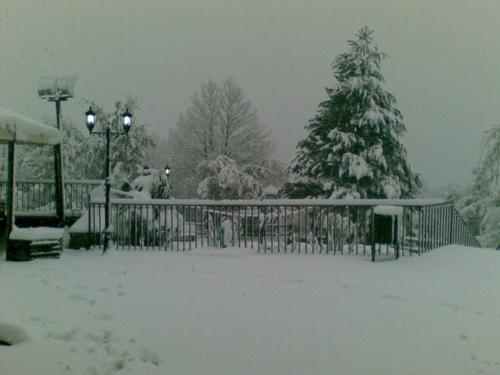 a snow covered yard with a fence and a christmas tree at Ai Vecchi Crateri in SantʼAlfio