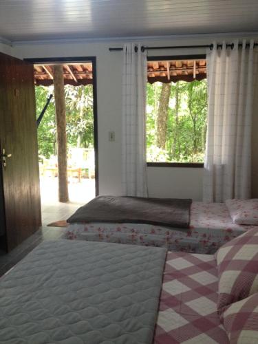 um quarto com 2 camas e 2 janelas em Entre Arvores Refúgio em Lumiar