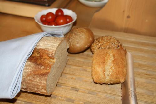 two loaves of bread and a knife on a cutting board at Pension Schusterpeter in Bad Tölz
