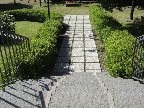a stone path in a garden with a fence at Ai Vecchi Crateri in SantʼAlfio