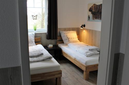 a small room with two beds and a window at Haus Kornfeld in Oberlangen